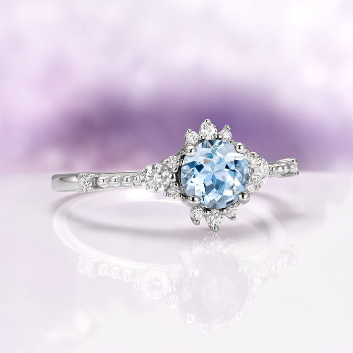 Vintage Round Cut Aquamarine Ring in Sterling Silver featuring a delicate round aquamarine center with sparkling diamond accents on an intricate sterling silver band by Aquamarise.