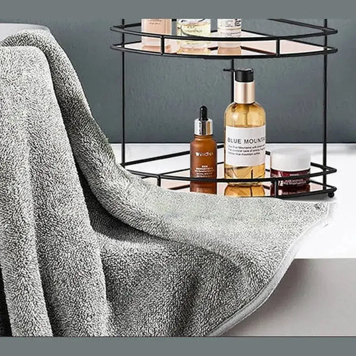 Black wall-mounted bathroom corner shelf showcasing toiletries with a gray towel draped across the edge.