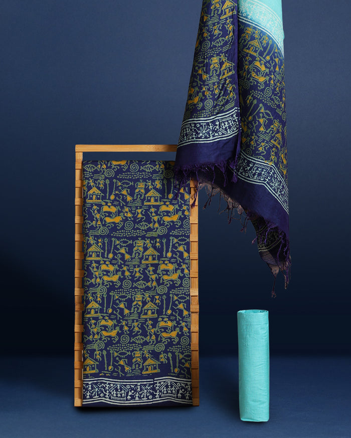 Dark blue Katan silk unstitched suit set hand block printed with small yellow Warli figures, huts and animals in a dense all-over repeat, with a linear motif border band at the hem and light blue accents.