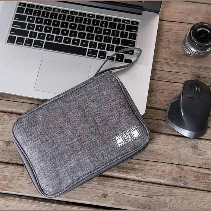 Waterproof electronics organizer bag on a desk beside a laptop.