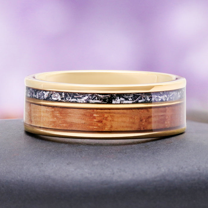 Whiskey barrel meteorite band on slate, showing the warm grain of the oak against yellow gold