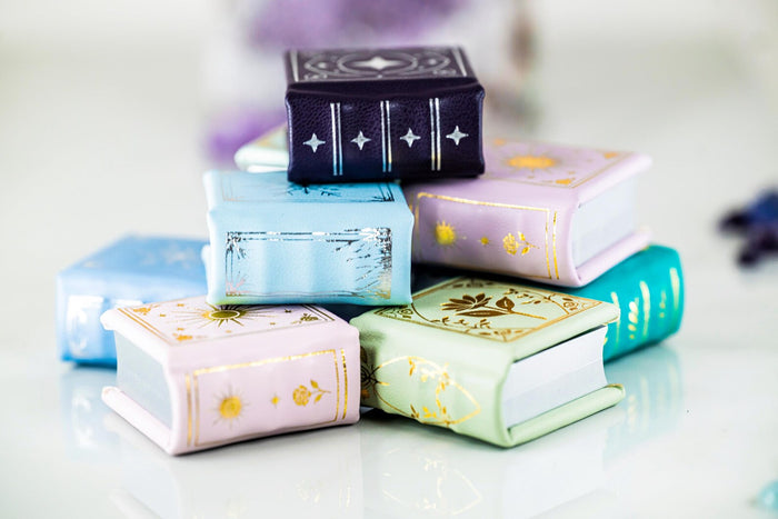 Summer Court Handmade Leather Book Ring Box- Seaglass Glow Edition (Small) displayed with other pastel-colored handmade book ring boxes by Aquamarise, perfect for symbolic jewelry gifts.
