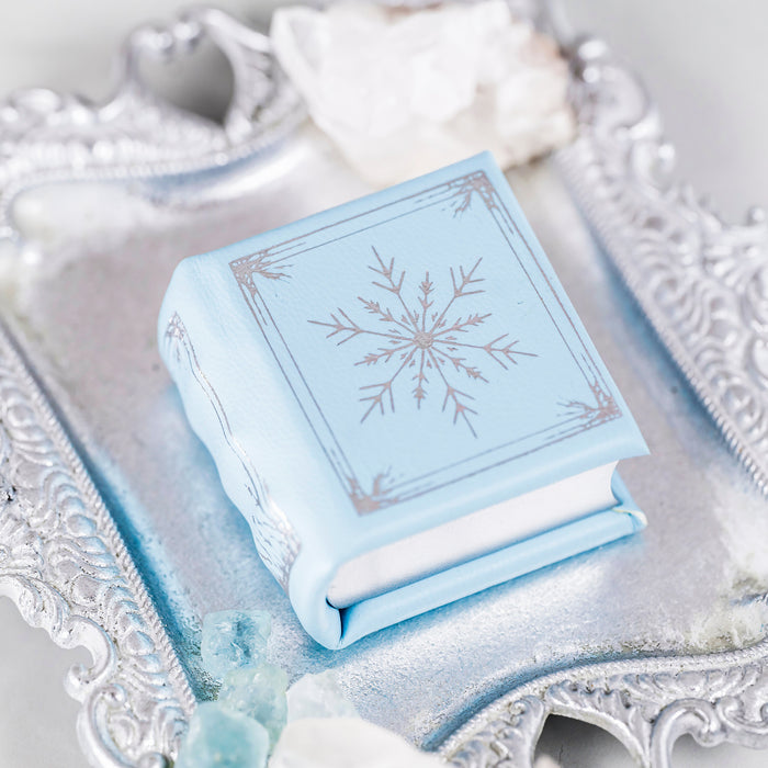 Winter Court Leather Book Ring Box – Glacier Mist Edition (Small) by Aquamarise, handmade blue leather book-style keepsake box with snowflake design, ideal for meaningful jewelry gifts.