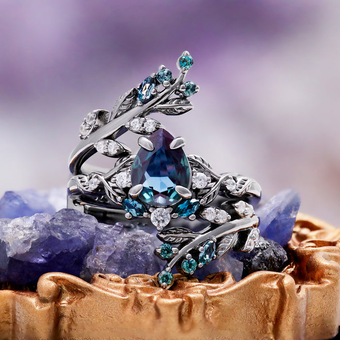 Wisteria alexandrite fairy leaf ring set in black ruthenium displayed on a crystal