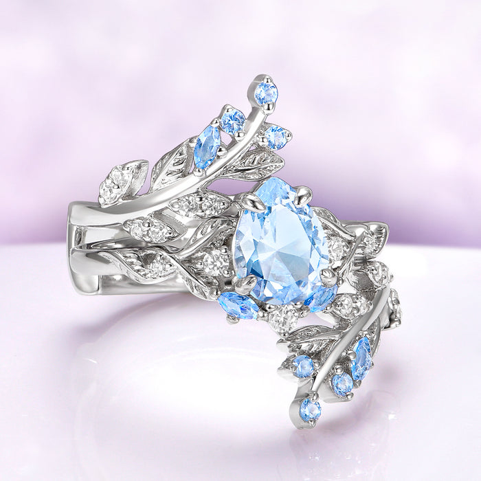 Wisteria Aquamarine Fairy Leaf Ring- 14K White Gold (Two Piece) featuring a marquise aquamarine center with intricate leaf-inspired white gold and delicate blue gemstone accents by Aquamarise Gold.