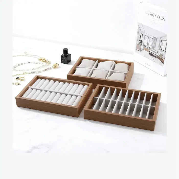 Wooden velvet jewelry tray organizer displayed with various compartments for rings and bangles on a marble surface.